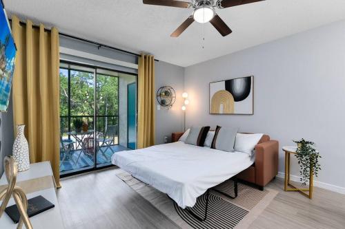 a bedroom with a large bed and a balcony at Oasis 203 - Symmetry & Serenity in Titusville