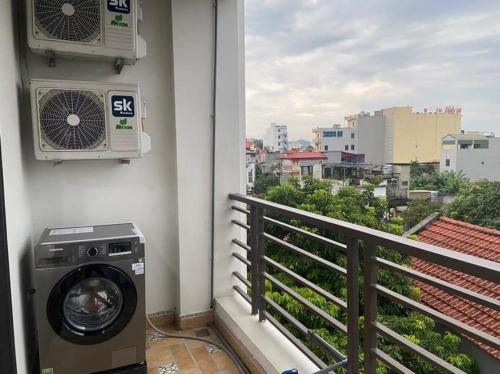 uma máquina de lavar roupa numa varanda com vista para a cidade em Căn hộ 1PN em Ninh Binh