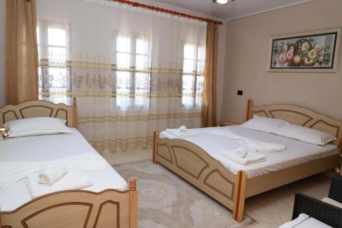 um quarto com 2 camas e uma janela em Guest House LION em Berati
