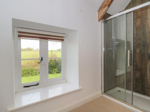 baño con ducha y ventana en Brook Cottage, en Sturminster Newton