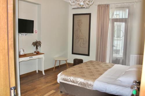 sypialnia z łóżkiem, biurkiem i telewizorem w obiekcie Luxor Gardens w mieście Batumi
