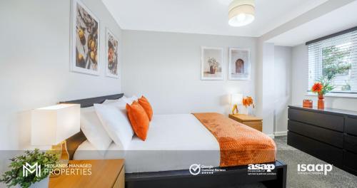 Schlafzimmer mit einem Bett mit weißer Bettwäsche und orangefarbenen Kissen in der Unterkunft Modern City Centre Apartment. Private Entrance, Garden, Parking, Garage, Quiet Neighbourhood in Peterborough