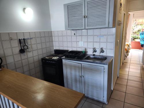 a small kitchen with a sink and a stove at Driftsands Sea View Flats in Uvongo Beach