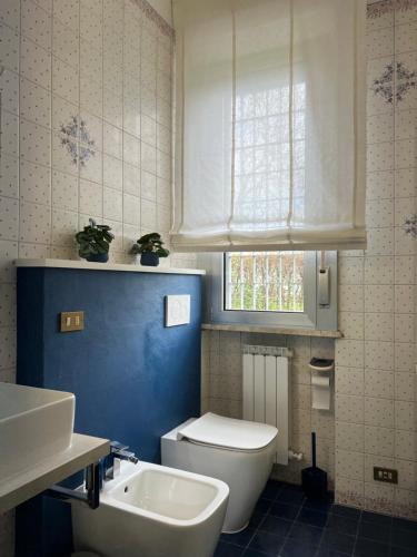 La salle de bains est pourvue de toilettes blanches et d'un lavabo. dans l'établissement Suite Piero della Francesca, à Prato