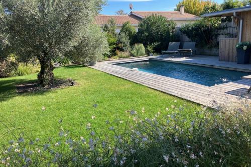 um quintal com uma piscina e uma árvore em Sumptuous Cap Ferret Style House em La Teste-de-Buch