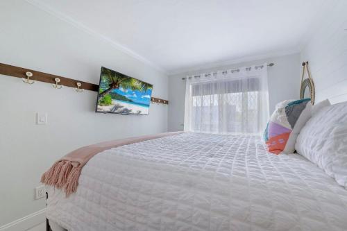 那不勒斯的住宿－Modern Condo With Pool Steps From Vanderbilt Beach，白色的卧室设有一张大床和一个窗户
