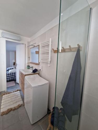a small bathroom with a sink and a refrigerator at Leukif - Appartement T4 Duplex 4* avec Rooftop in Leucate