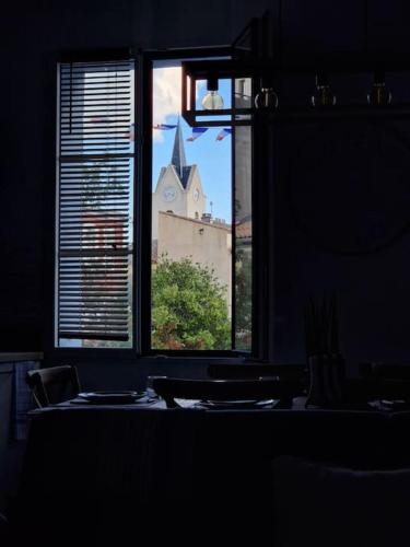a window with a view of a church seen through it at Leukif - Appartement T4 Duplex 4* avec Rooftop in Leucate
