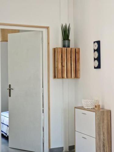 a room with a door and a cabinet with a plant at Leukif - Appartement T4 Duplex 4* avec Rooftop in Leucate