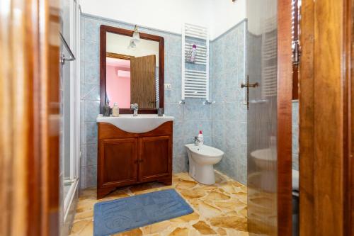 La salle de bains est pourvue d'un lavabo, de toilettes et d'un miroir. dans l'établissement Casa Ai Cappuccini, à Randazzo