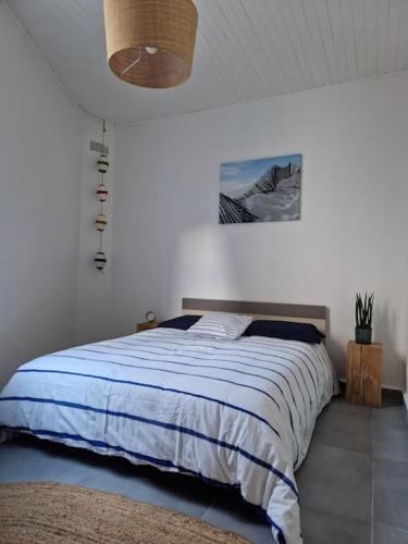 a bedroom with a bed with a blue blanket at Leukif - Appartement T4 Duplex 4* avec Rooftop in Leucate