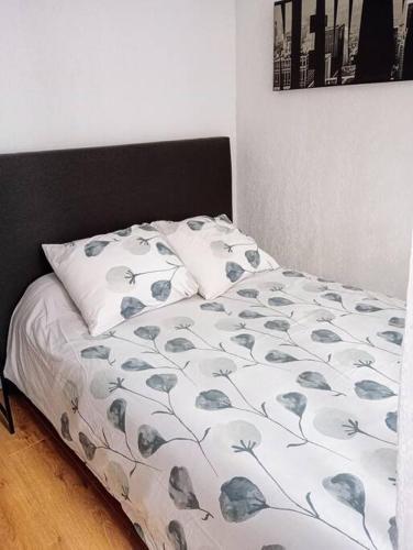 - un lit avec une couette blanche et une tête de lit noire dans l'établissement Appartement proximité gare, à Perpignan