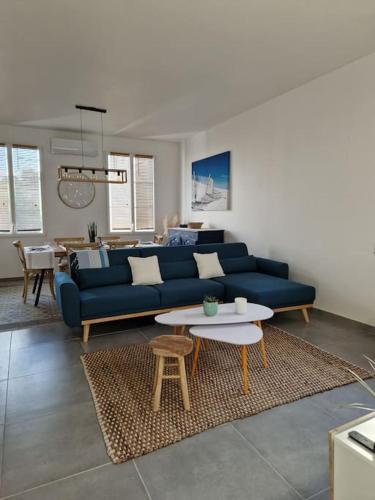 a living room with a blue couch and a table at Leukif - Appartement T4 Duplex 4* avec Rooftop in Leucate