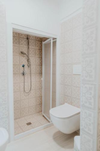 a white bathroom with a shower and a toilet at Casa tutti i frutti in Noci