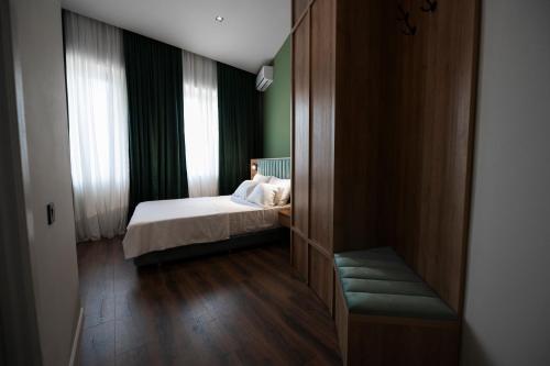 a small bedroom with a bed and a window at Central Hotel Kutaisi in Kutaisi