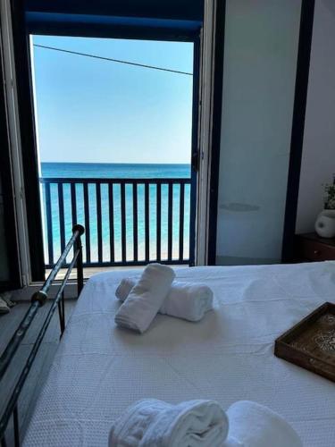 a bedroom with a bed with a view of the ocean at Μεζονέτα - Παραλία Αγία Φωτεινή in Chios