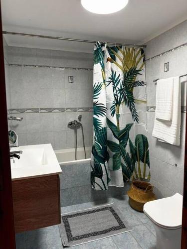 a bathroom with a sink and a tub and a shower curtain at Μεζονέτα - Παραλία Αγία Φωτεινή in Chios