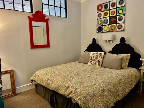 a bedroom with a bed and a mirror on the wall at Hampton Court Grand Snug Sleeps 6 - Walk to Palace and Train in Molesey