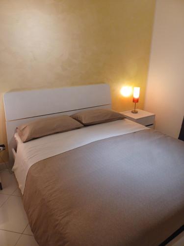 a bedroom with a large bed and a lamp on a table at Soleil in Nicosia