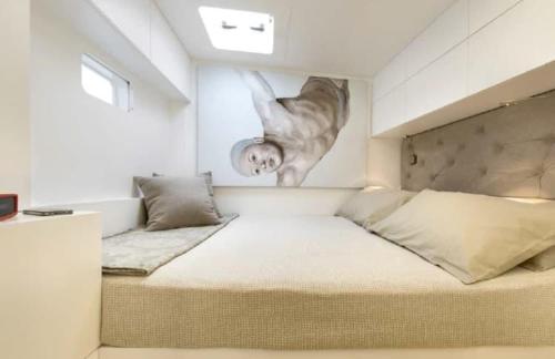 a bedroom with a large bed with a painting on the wall at Luxury catamarano 20 meters in Marina di Portisco
