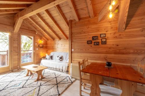 a log cabin with a table and a couch at Auberge du coin in Saint-Colomban-des-Villards