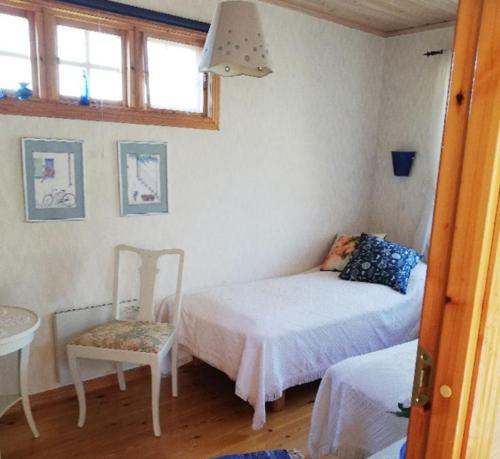 a bedroom with two beds and a table and a chair at House with lake plot and own jetty on Skansholmen outside Nykoping in Nyköping