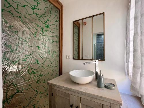 ein Bad mit einem Waschbecken und einem Spiegel in der Unterkunft Dilà Assisi Rooms in Assisi