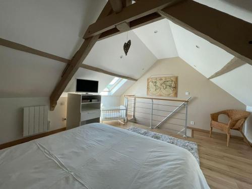 une chambre avec un grand lit dans un grenier dans l'établissement Maison de famille avec SPA, à Clécy