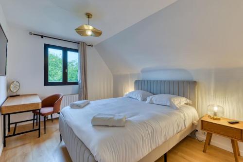 - une chambre avec un grand lit blanc et un bureau dans l'établissement Yann : Détente et Confort près de Rouen, à Sotteville-lès-Rouen