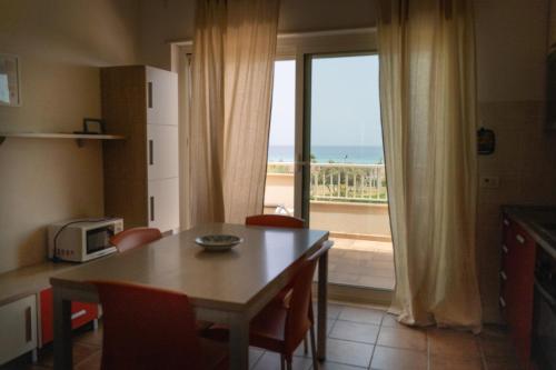 a kitchen with a table and a view of the ocean at Agua Residence in Noto