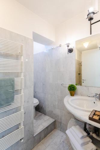a white bathroom with a sink and a mirror at Georgia Modern Panoramic Penthouse with Elevator in Lucca