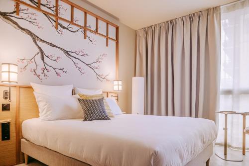 a bedroom with a bed with a branch on the wall at Sangha Toulouse in Toulouse