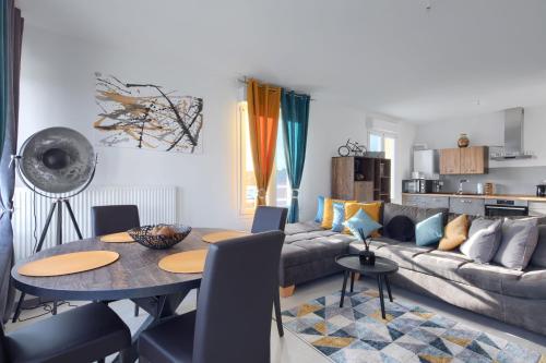 una sala de estar con una mesa y un sofá en La Casa Metzervisse, en Thionville