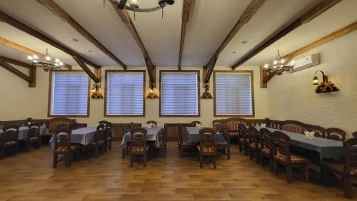 a dining room with tables and chairs and windows at Xəzər İstirahət Mərkəzi in Bunud