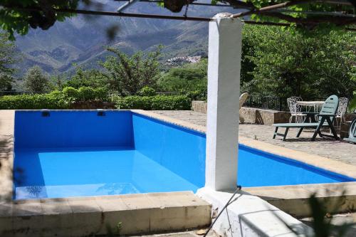 una piscina azul con mesa y sillas en Casa rural el Ayozar, en Albanchez de Úbeda