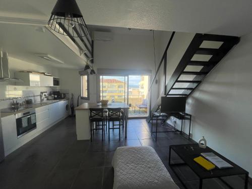 Il comprend une cuisine et un salon avec une table et un escalier. dans l'établissement Appartement 40m2 - Bord de mer, à Frontignan