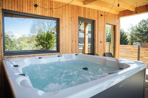 a large white tub in a room with windows at Koliberek Apartament SPA in Szalejów Górny