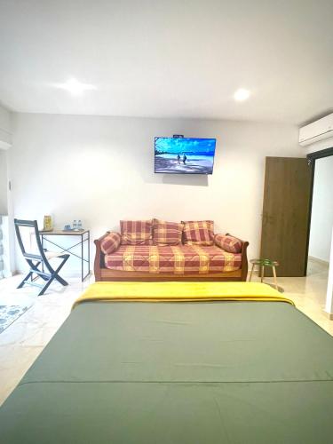 a living room with a couch and a tv on the wall at Villa Rose Marie Calme et Grands Espaces in Le François