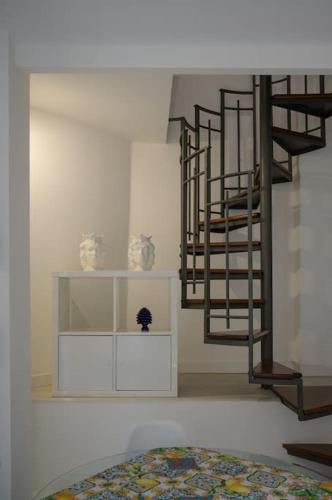 a bedroom with a spiral staircase and a bed at Casa Vacanze Marta Aci Trezza in Aci Castello