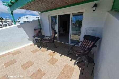 a patio with chairs and a table on a balcony at Coqueto apart en Las Coronas in Costa Teguise