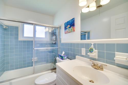 baño de azulejos azules con lavabo y aseo en Dog-Friendly Vero Beach Home Less Than 7 Mi to Coast! en Vero Beach