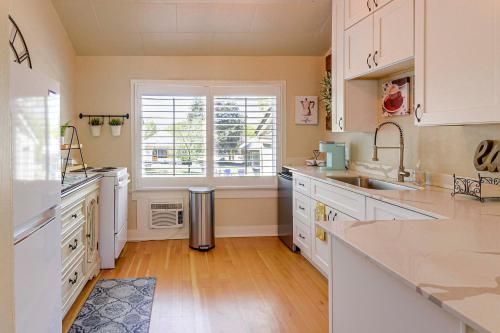 a kitchen with white cabinets and a sink and a window at Walk to Courthouse Square Quiet Home with Porch in Prescott