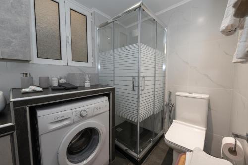 a bathroom with a washing machine and a toilet at MP Captain's House in Gythio
