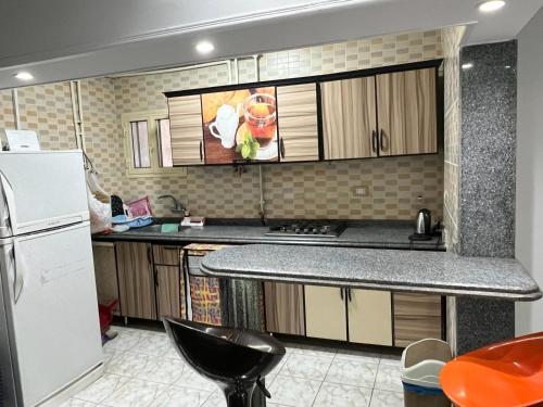 - une cuisine avec des placards en bois et un réfrigérateur blanc dans l'établissement Nice apartment in mostafa kamel city square, à Alexandrie