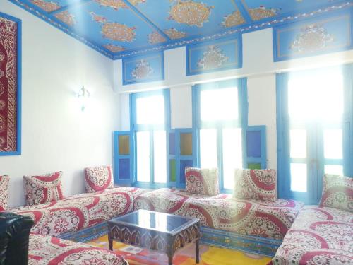a living room with red and white furniture and windows at hotel Casa Love Dreams chefchaouen in Chefchaouene
