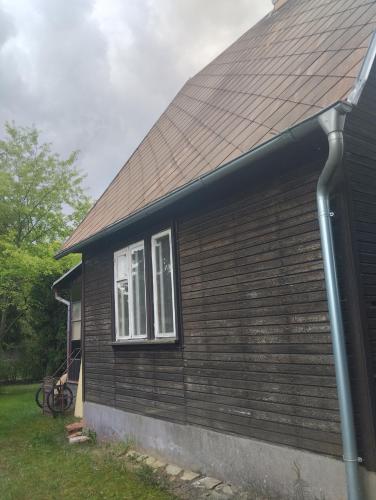 a house with a brown roof and two windows at Domek v přírodě Hradec Králové in Hradec Králové