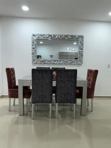 stół jadalny z krzesłami i lustrem w obiekcie Espectacular apartamento central w mieście Montería