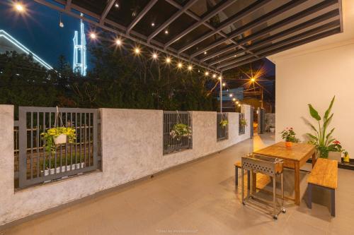 a patio with a table and a fence at Lucia House in Ấp Kim Thạch