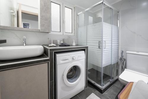 a bathroom with a washing machine and a sink at MP Captain's House in Gythio
