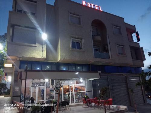 un bâtiment avec un panneau d'hôtel sur son côté dans l'établissement hotel khaouni bourdj bou arraredj, à Bordj Bou Arreridj